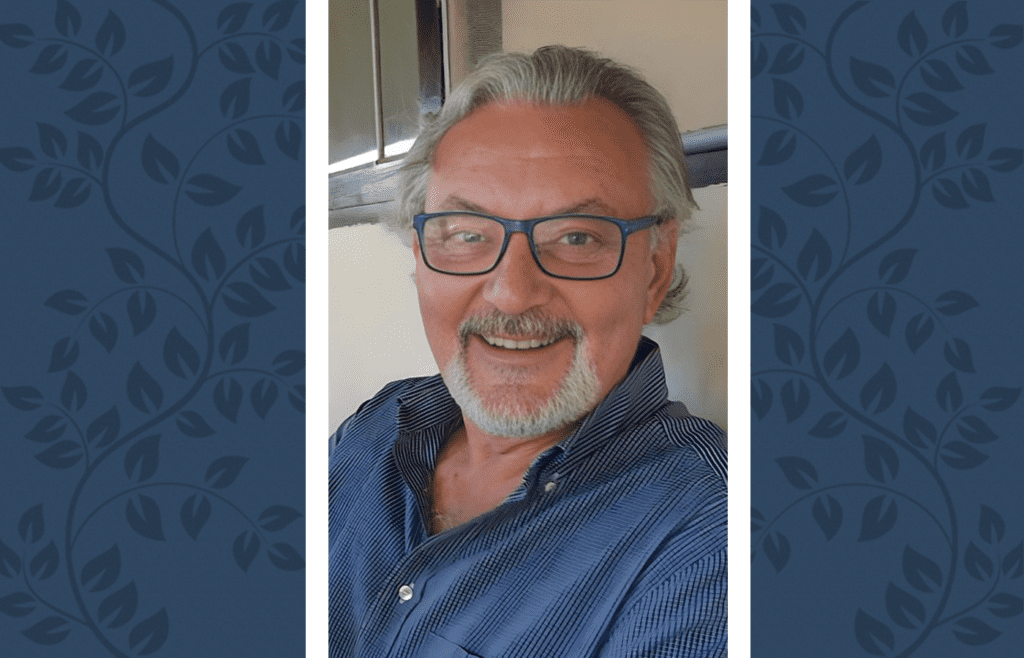 Foto de Manuel Malheiro em um fundo azul com ramos laterais de louros.