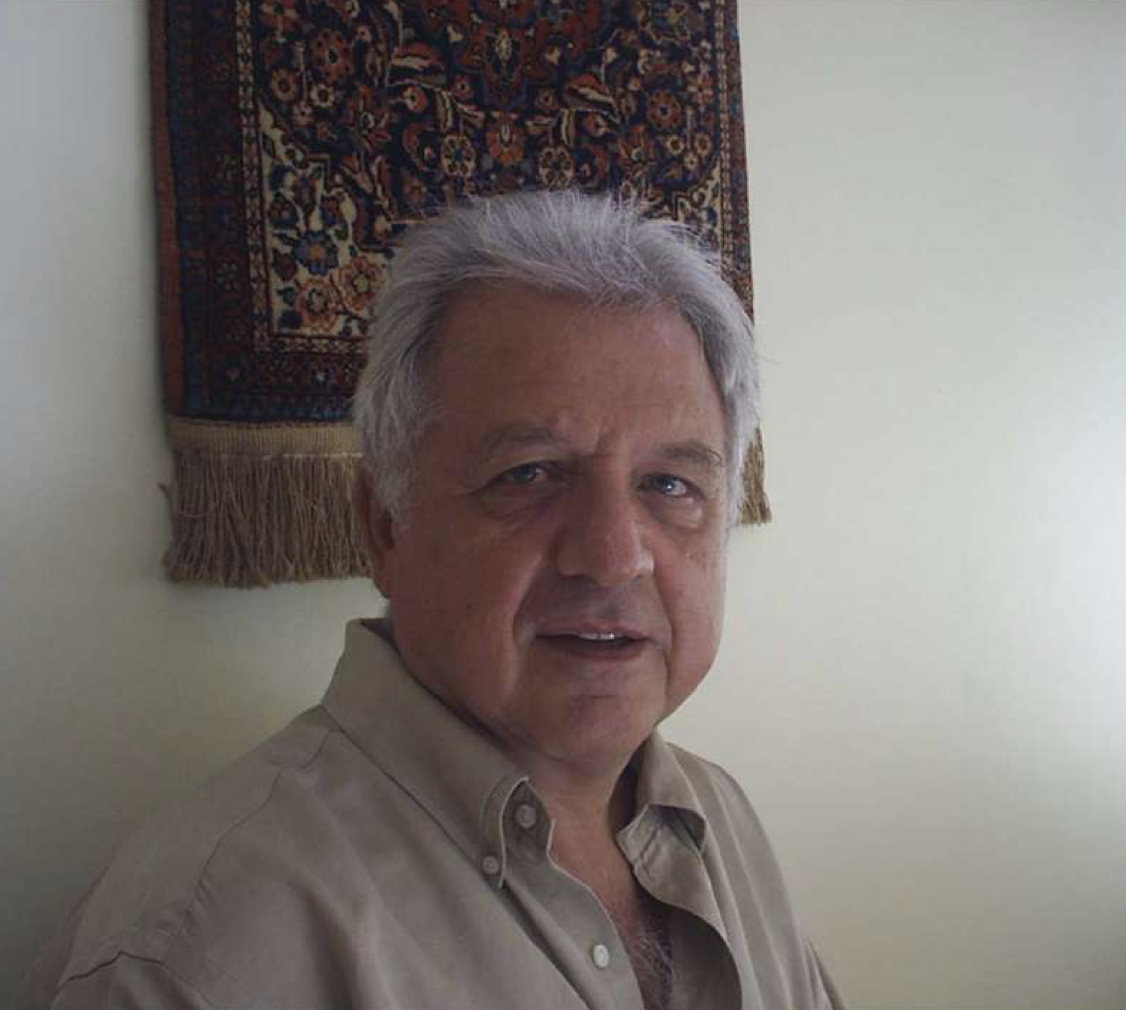 Foto de busto do professor Constantino Tsallis, um senhor branco, de cabelos brancos e camisa bege.