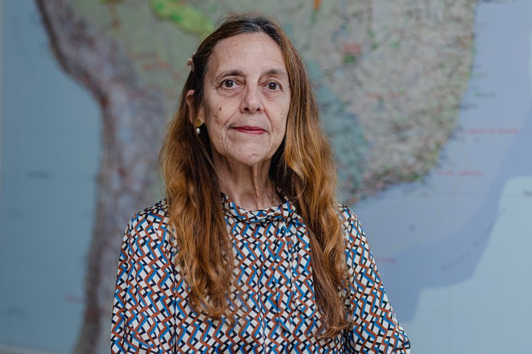 Professora de Física Andrea Latgé, mulher, idosa, branca de cabelos ruivos.